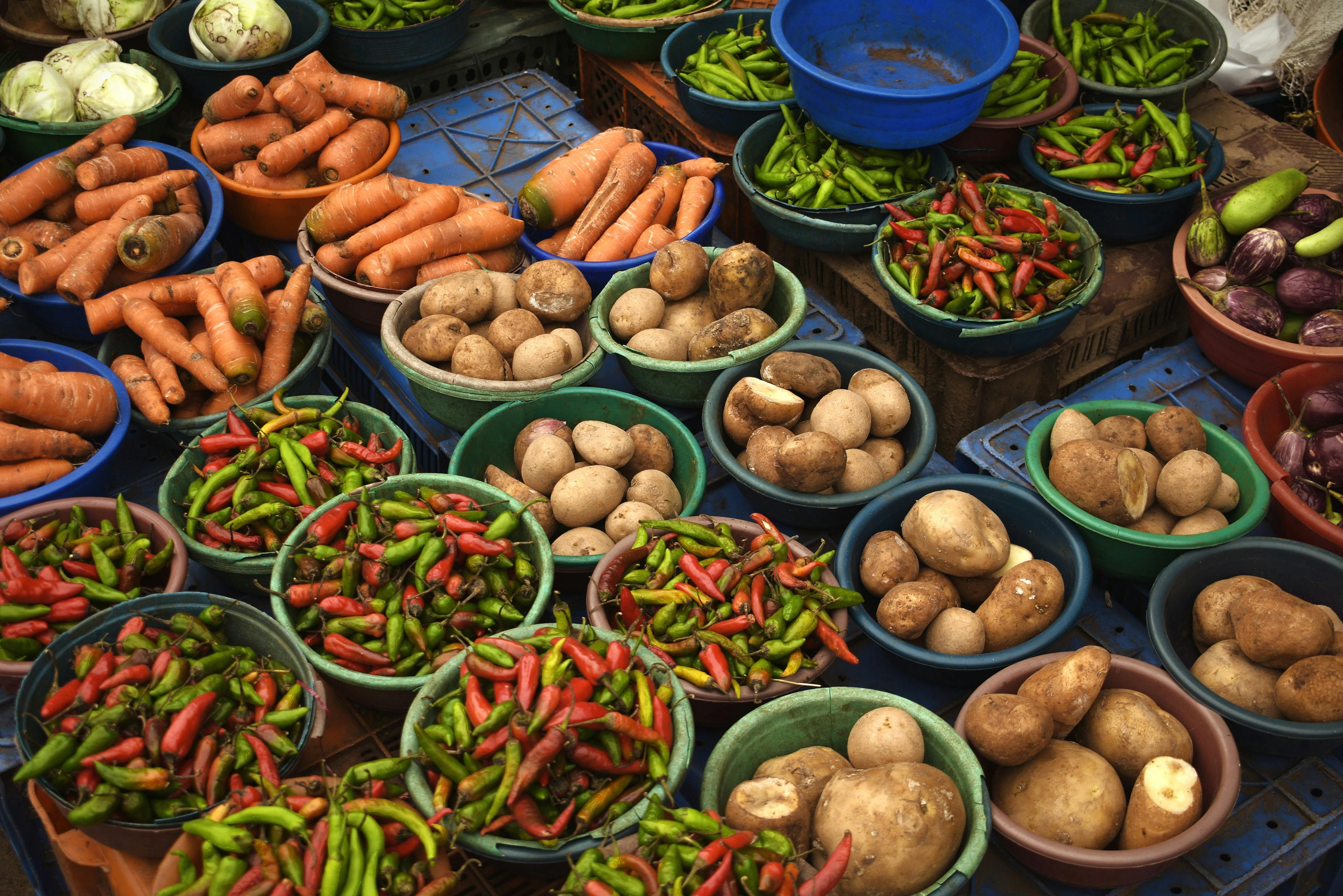 A colorful assortment of carrots, potatoes, and peppers at a local vegetable market.