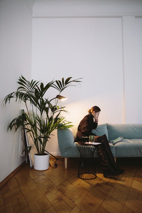 Photo Of Woman Sitting Beside Indoor Plant