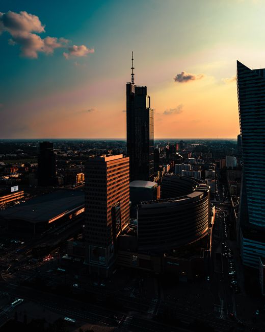 Aerial view of a modern city skyline at sunset, showcasing urban architecture in dusk light.