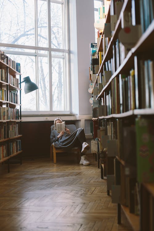 Free Woman Reading in Library Stock Photo
