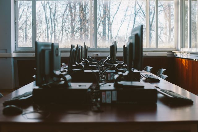 An empty computer lab with multiple workstations and large windows during the daytime. Related image for Cybersecurity: How Brands Can Improve Performance.