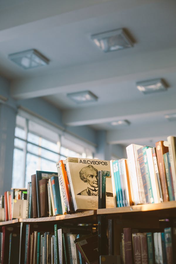 Person engrossed in reading a book in a library setting