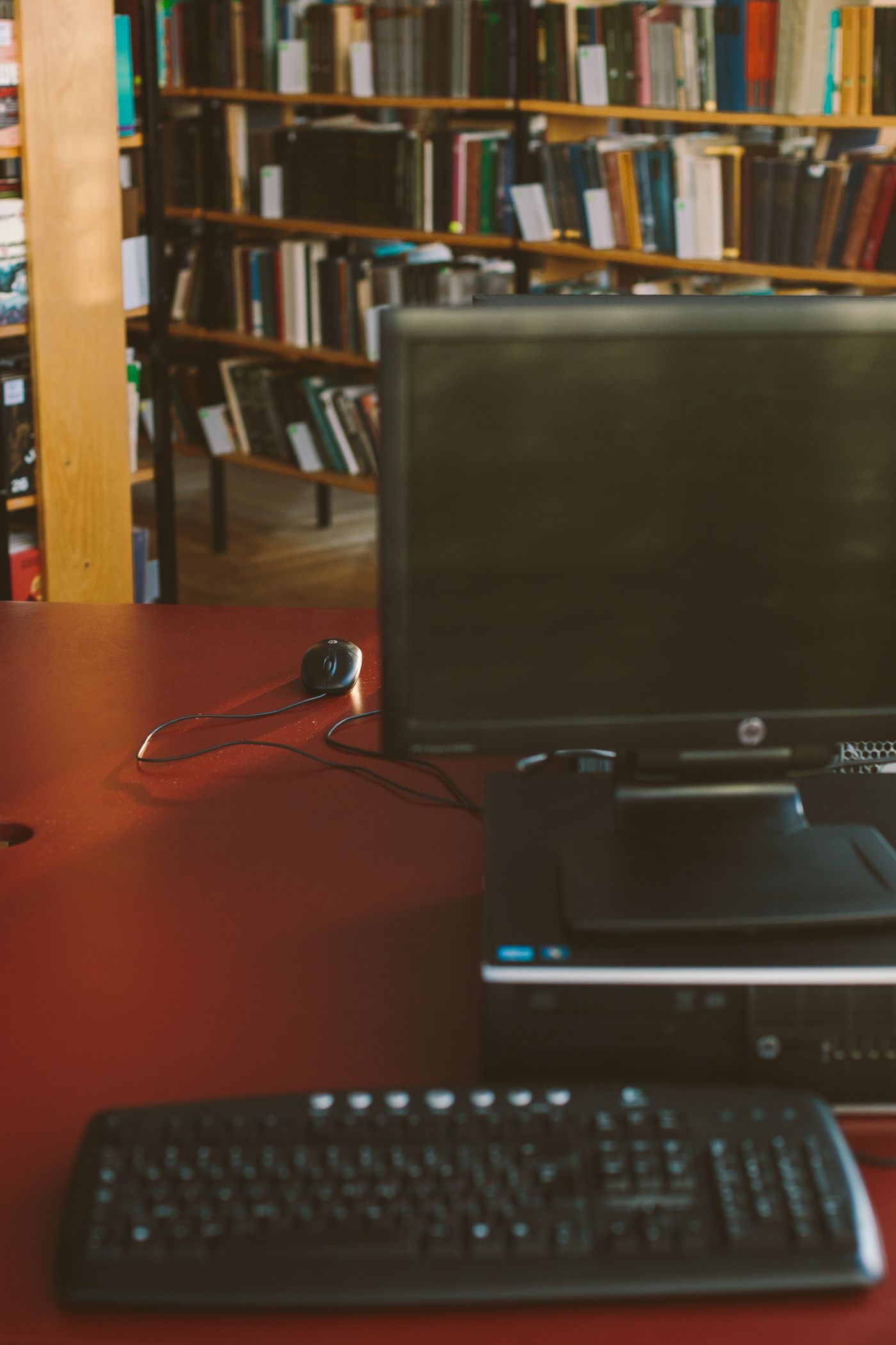 Poste informatique sur une table en bois dans une bibliothèque
