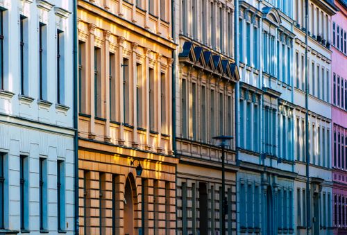 Row of pastel townhouse facades at golden hour — photo by wal_172619 on Pexels