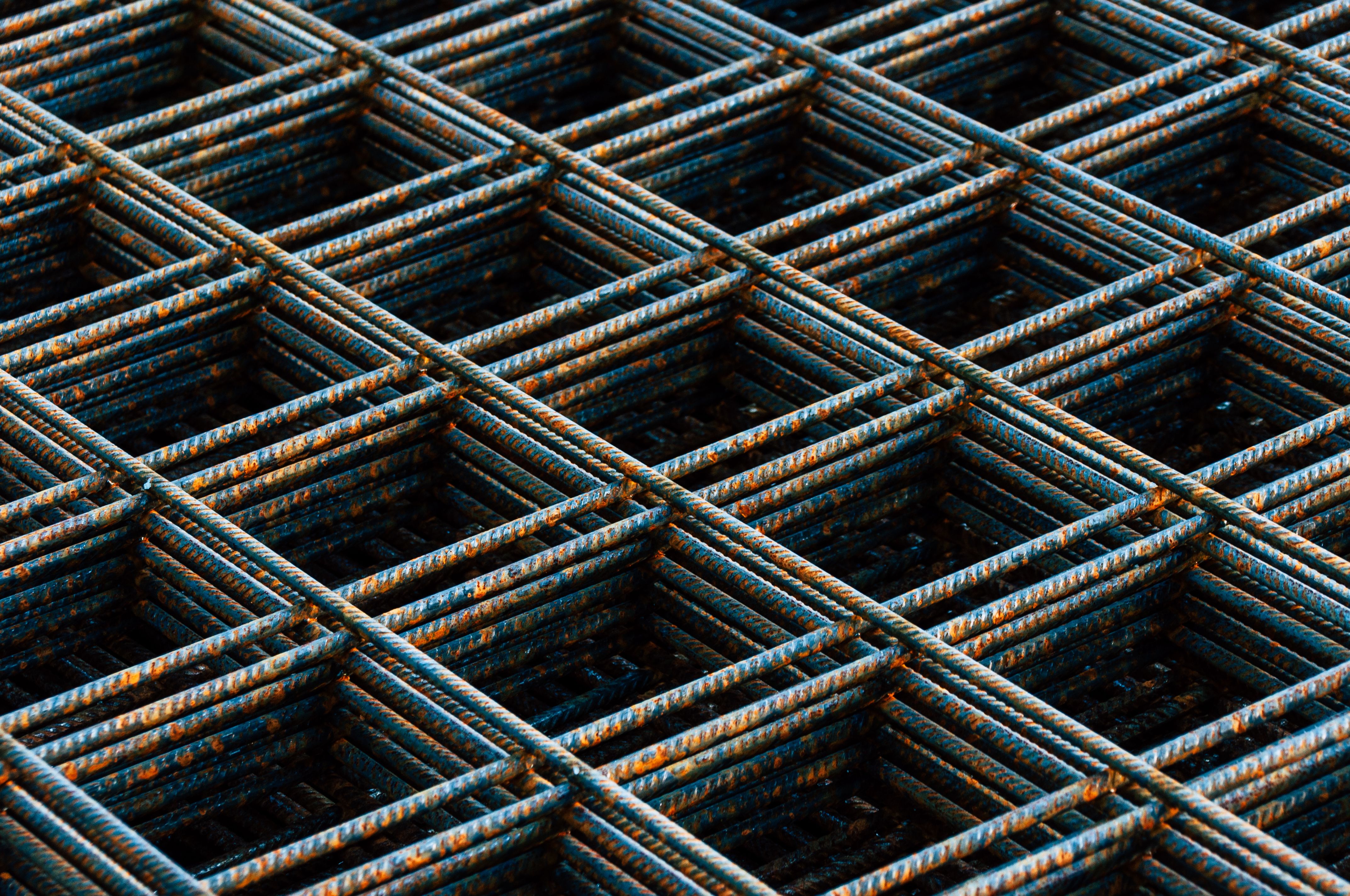 Detailed view of a rusty rebar grid used in construction work, showing texture and pattern.