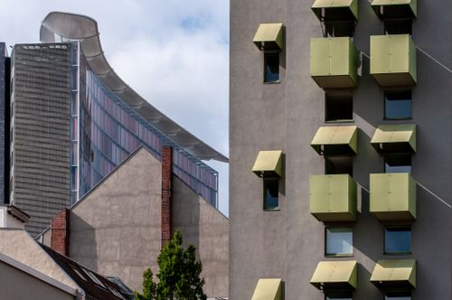 Free A juxtaposition of modern and traditional architectural designs under a clear blue sky. Stock Photo
