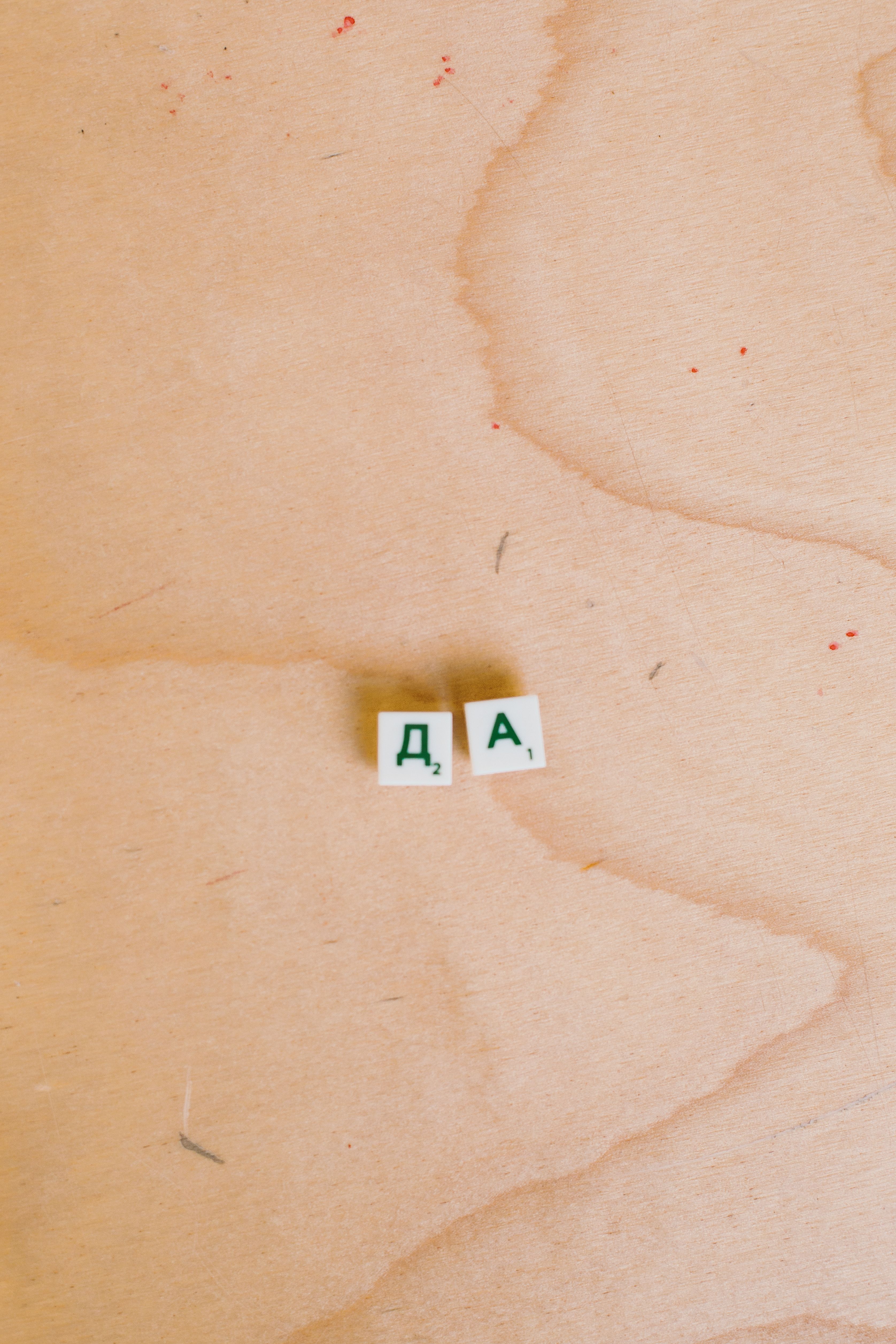 Close up of Cyrillic letter tiles on a wooden surface, ideal for educational or language themes.