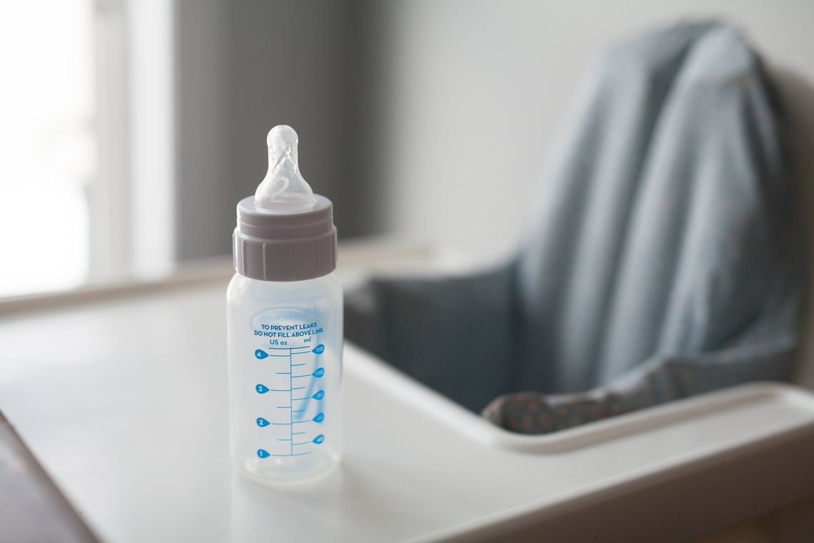 Baby bottle placed on a high-chair tray ready for a feeding routine