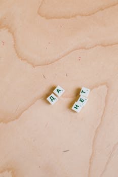 Cyrillic Scrabble tiles spelling words on a wooden background.