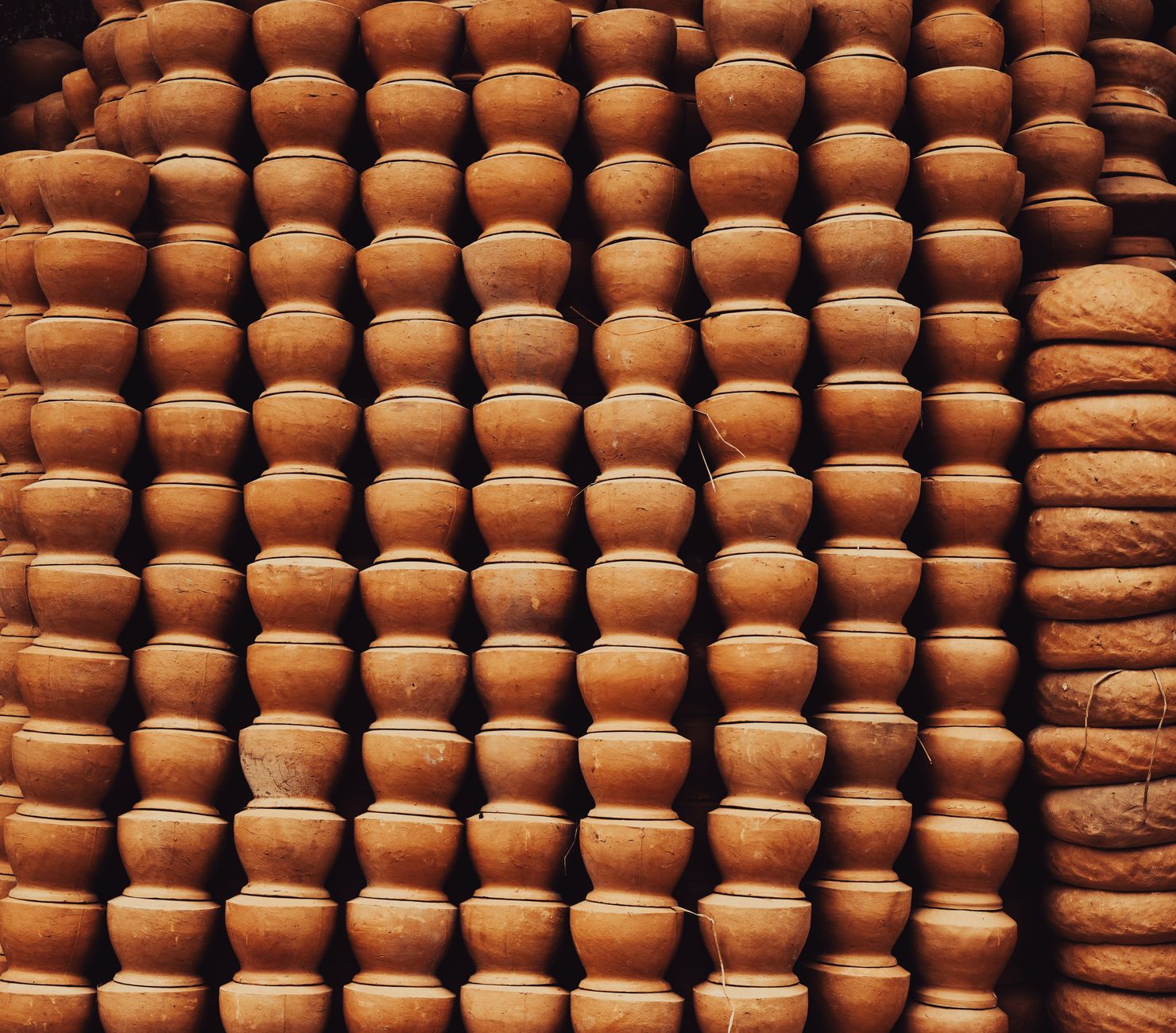 A close-up view of stacked terracotta pots, showcasing traditional craftsmanship and earthy tones.