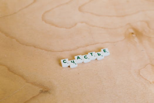 Scrabble tiles spelling Russian word on wooden surface. Creative game concept.