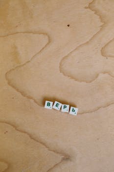 Cyrillic letter tiles arranged on a natural wooden surface.
