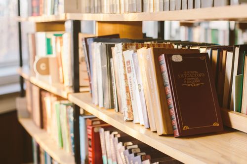 Free Close-up view of books on a sunlit library shelf, illustrating warmth and knowledge. Stock Photo