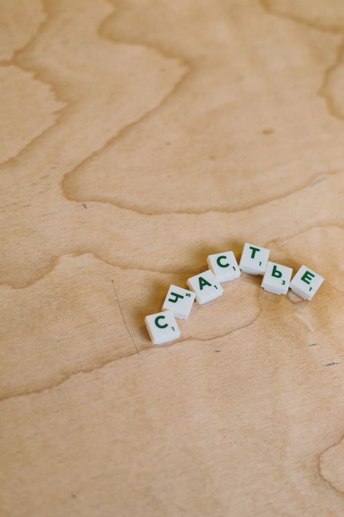 Free Cyrillic tiles spelling 'happiness' on a wooden board game setting. Stock Photo