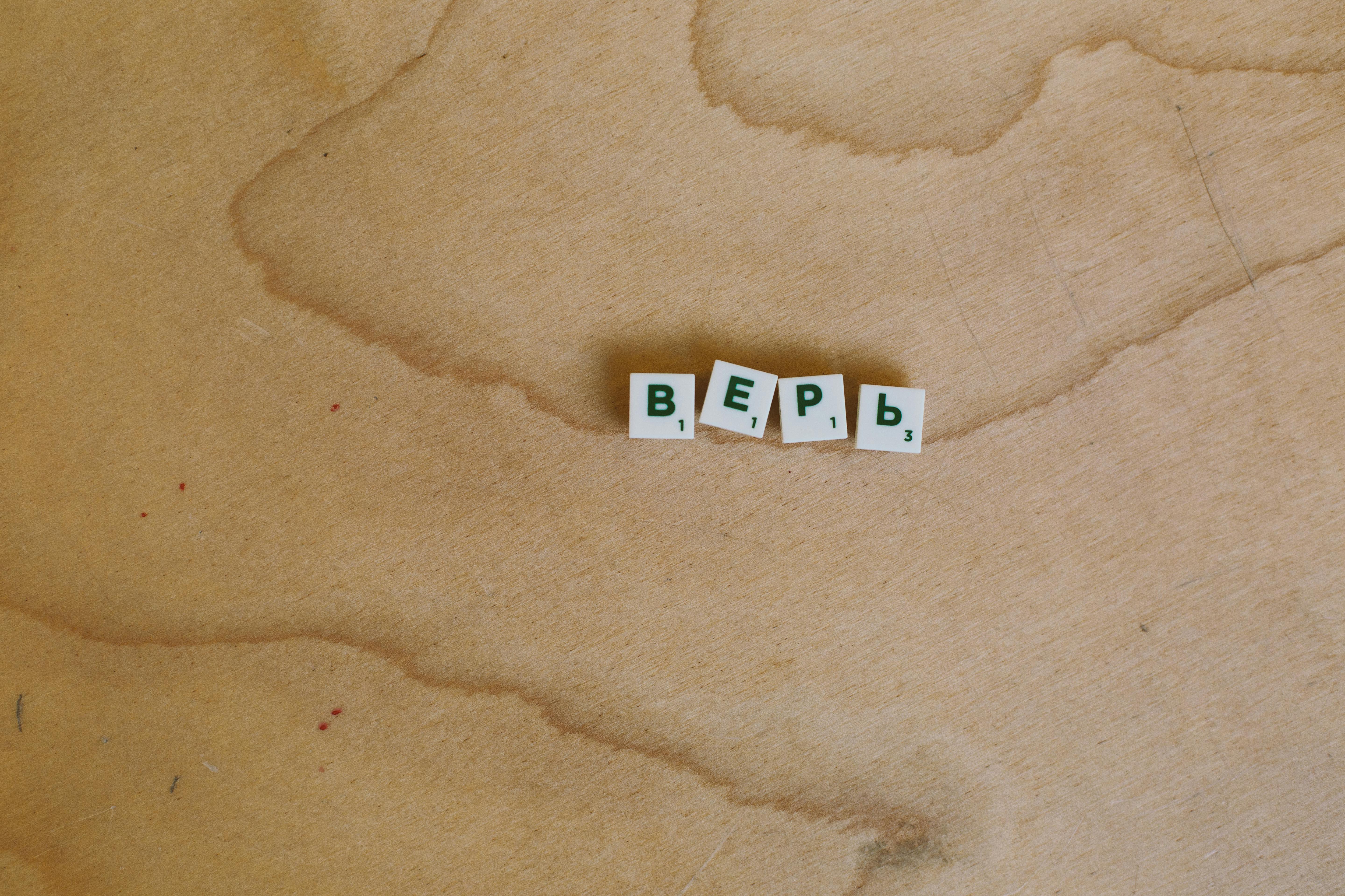 photo of scrabble pieces on wooden surface