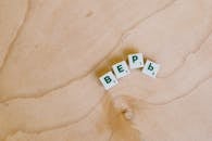 Photo Of Scrabble Pieces On Wooden Surface