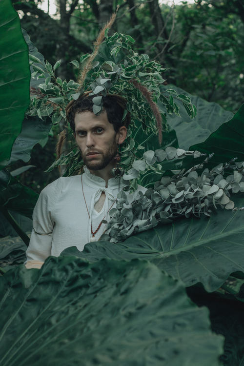 Free Man with plants and greenery, blending into forest background. Stock Photo