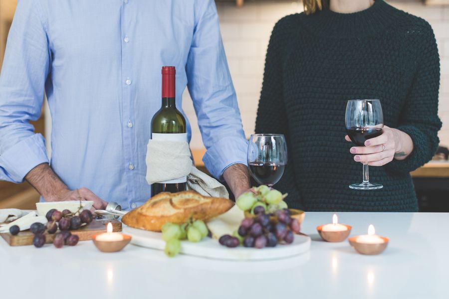 Friends sharing wine, grapes and bread at a harvest table