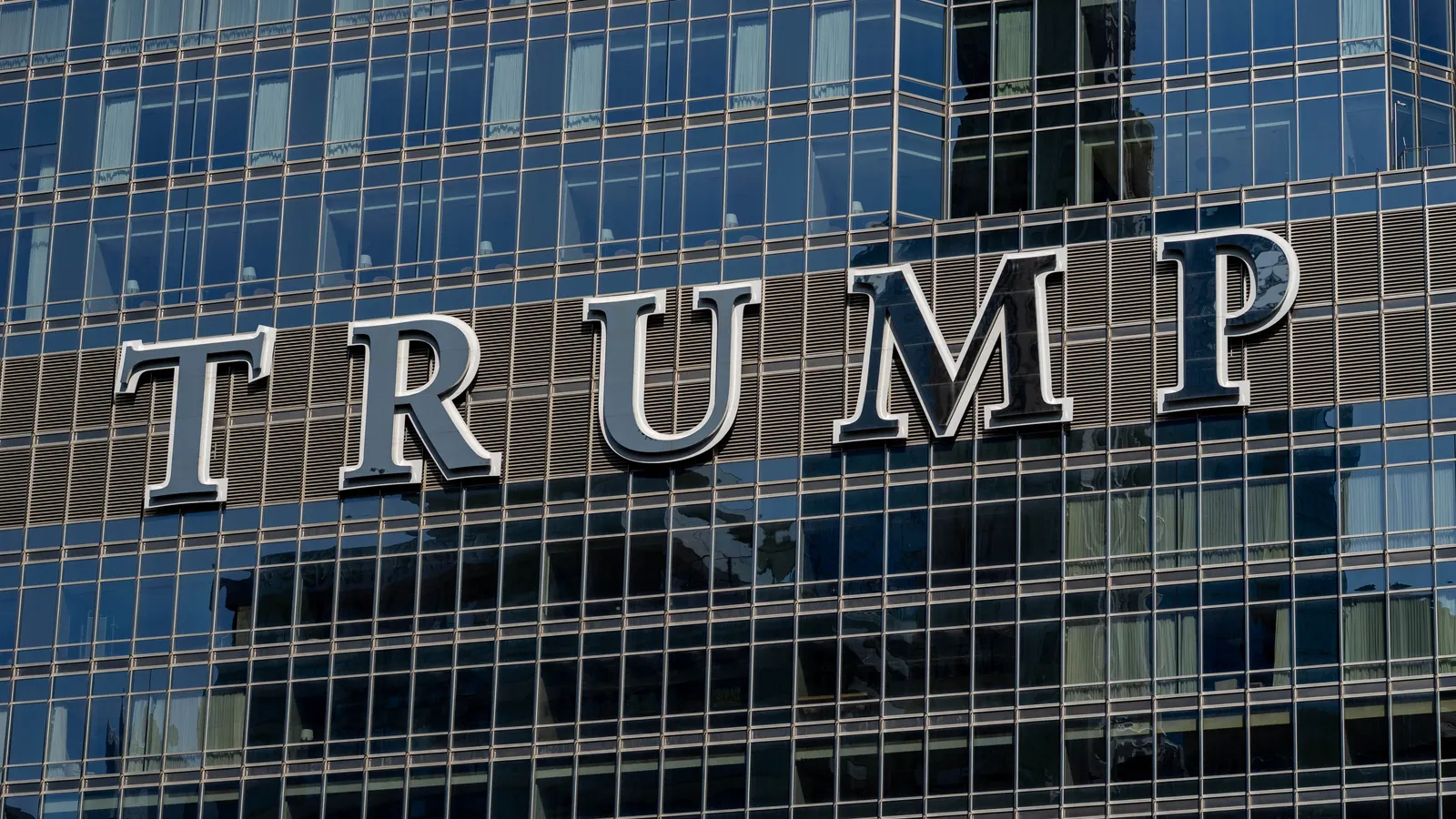 Detailed view of the Trump building facade, with reflective glass windows.