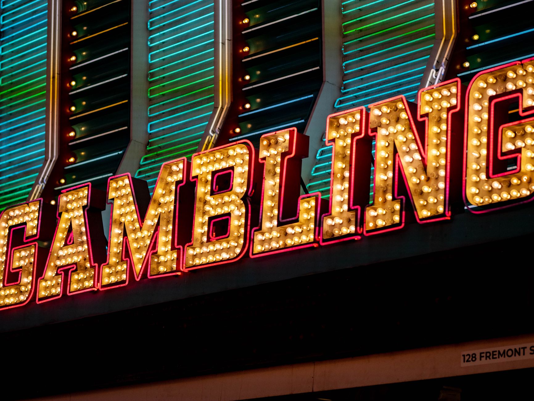 Bright neon sign displaying 'Gambling' with vibrant lights at night in Las Vegas.