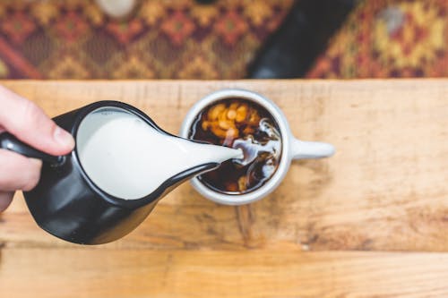 Person Pouring on White Ceramic Teacup