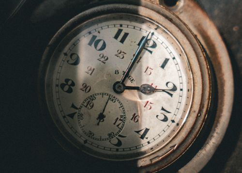 Free Close-up of a vintage pocket watch with intricate clock hands casting shadows. Stock Photo