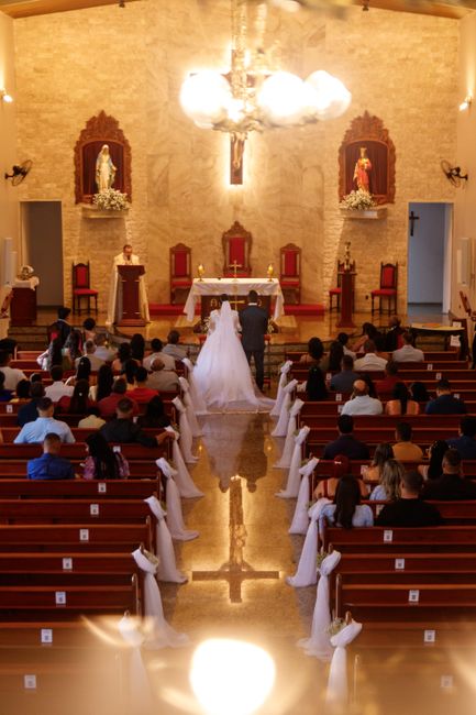 Fotomural Una ceremonia de boda elegante en una iglesia bellamente decorada con asistentes sentados en bancos.