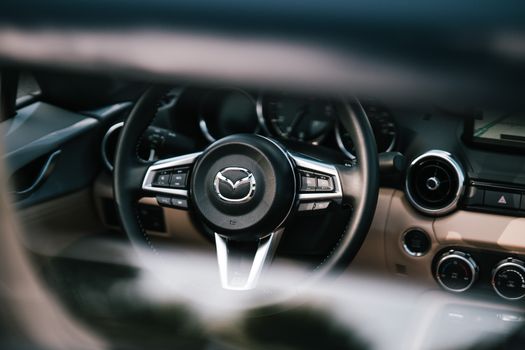 Detailed close-up of a car steering wheel, showcasing its design and interior elements.