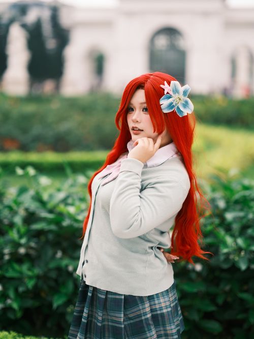 Free A captivating cosplay portrait of a person with red hair in a lush Vietnamese garden. Stock Photo