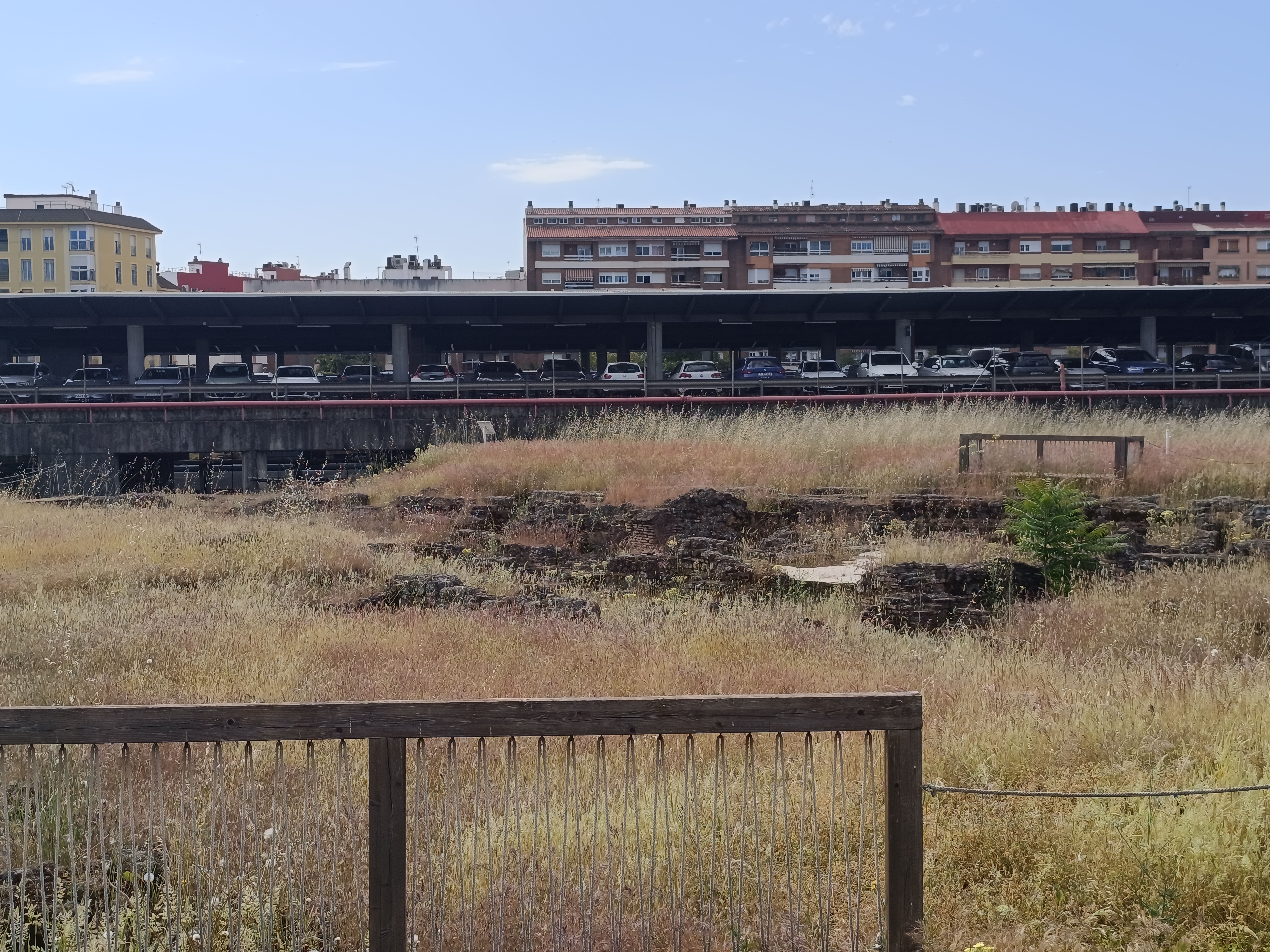 una panorámica del yacimiento arqueológico con la estación de ferrocarril al fondo