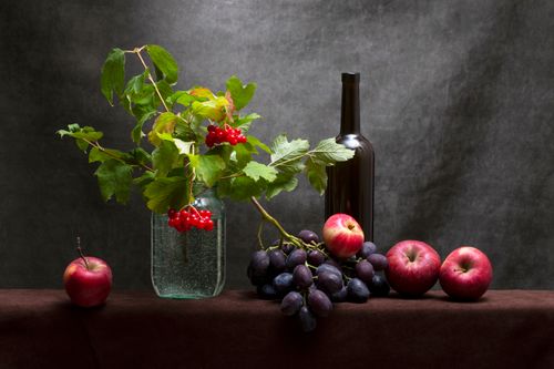 Free Elegant still life composition featuring apples, grapes, and a wine bottle. Stock Photo