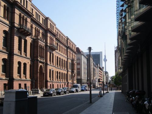 Free Captivating street view in Berlin featuring classic architecture and the Berlin TV Tower under a clear summer sky. Stock Photo