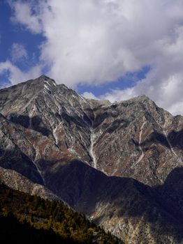 Stunning view of rugged mountains in Nako, Himachal Pradesh, under a dramatic cloudy sky.