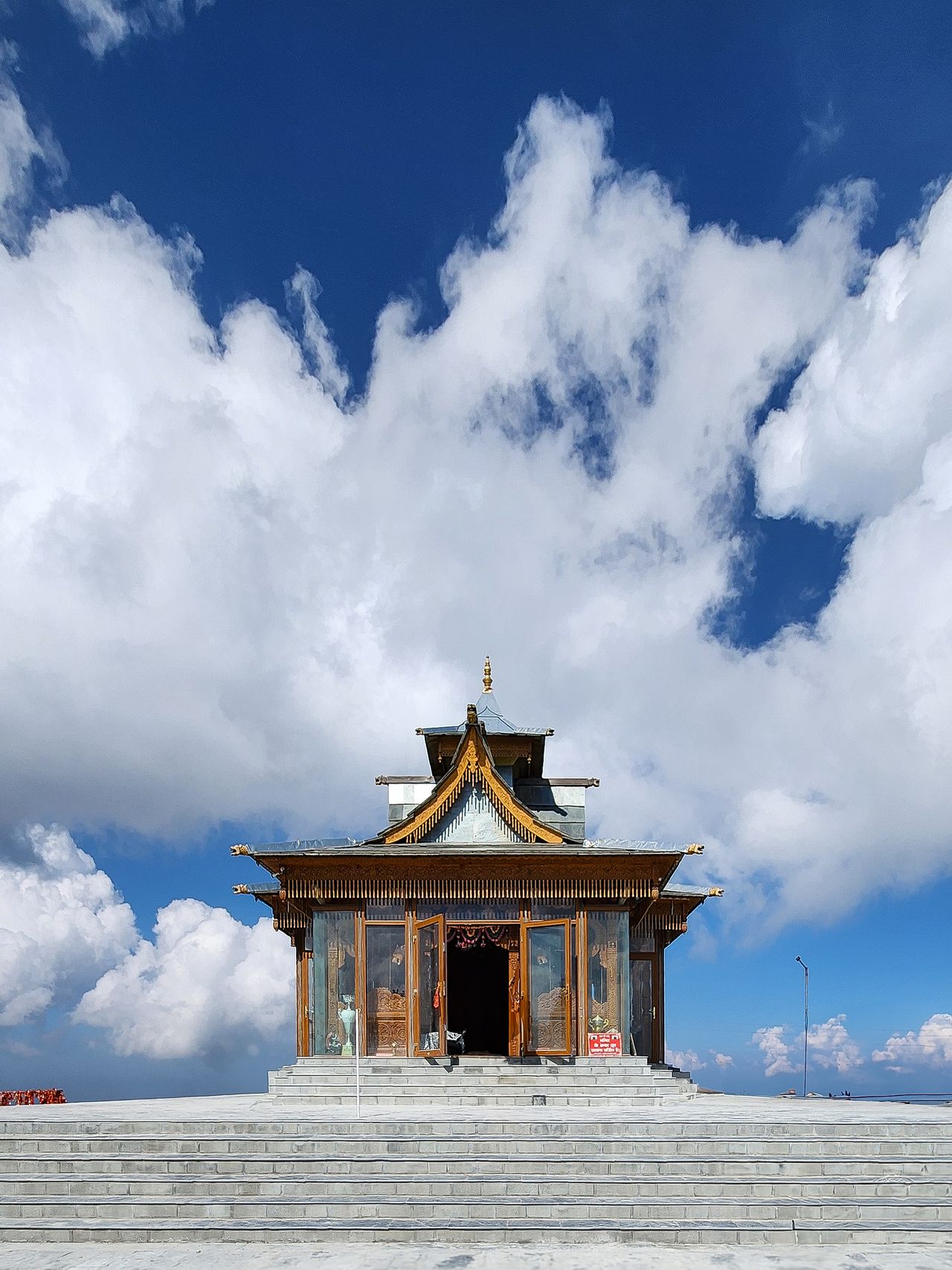 A traditional Himalayan temple under a bright blue sky at Narkanda