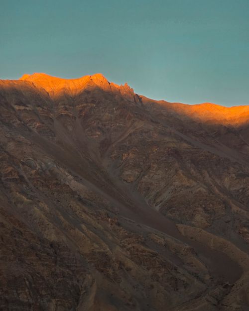 Free Stunning sunrise over the Zangla mountains with a golden glow at the peak. Stock Photo