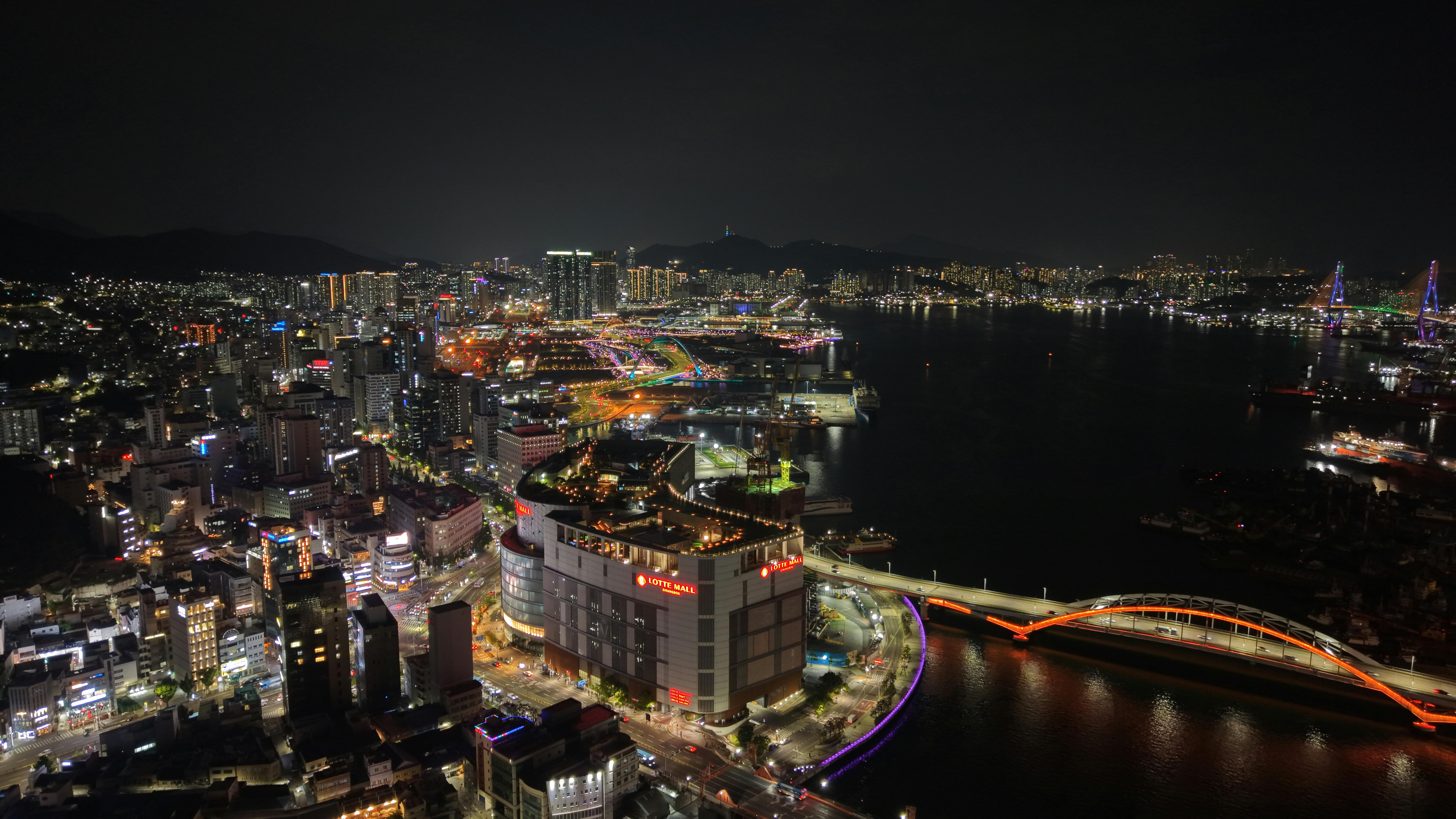 Stunning aerial night view of Busan, South Korea featuring the illuminated Gwangandaegyo Bridge.