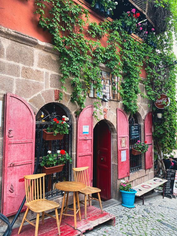Free Cozy cafe exterior with red shutters and green vines in Ankara, Türkiye. Perfect for city lifestyle imagery. Stock Photo