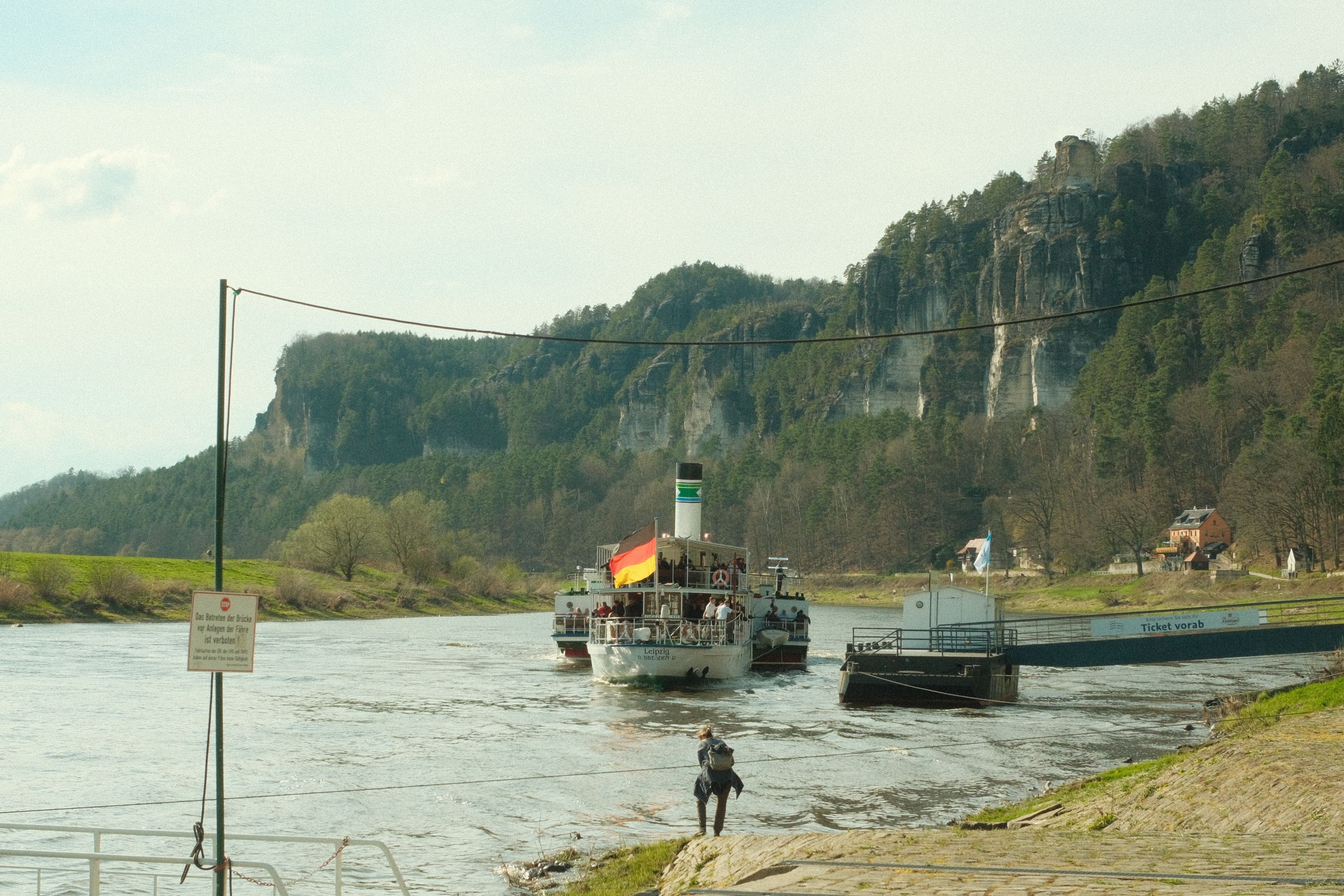 Paddle steamer on the Elbe River near scenic cliffs, Germany.