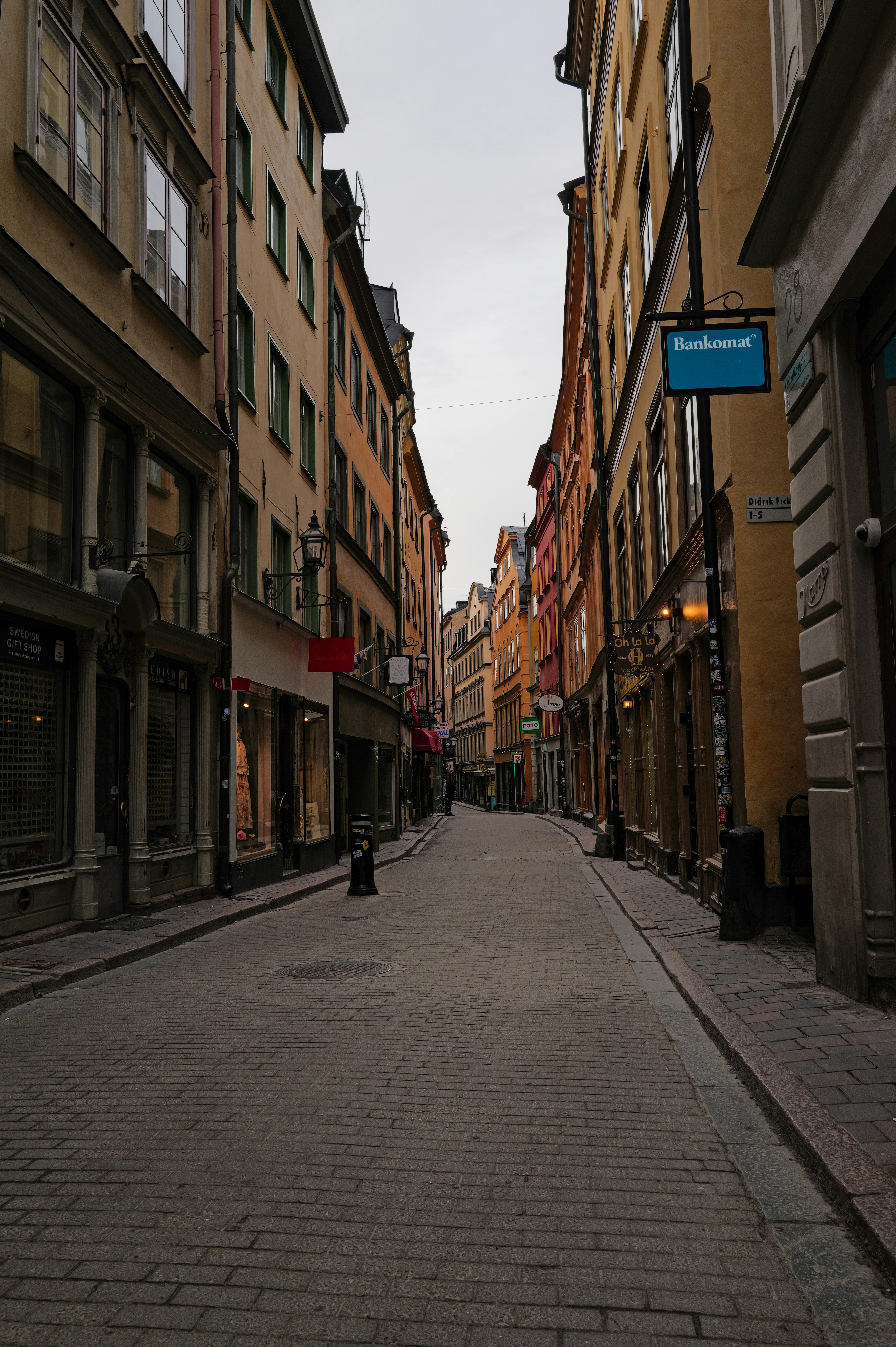 Explore the cobblestone streets of Stockholm's historic old town in this serene, empty alleyway photo.