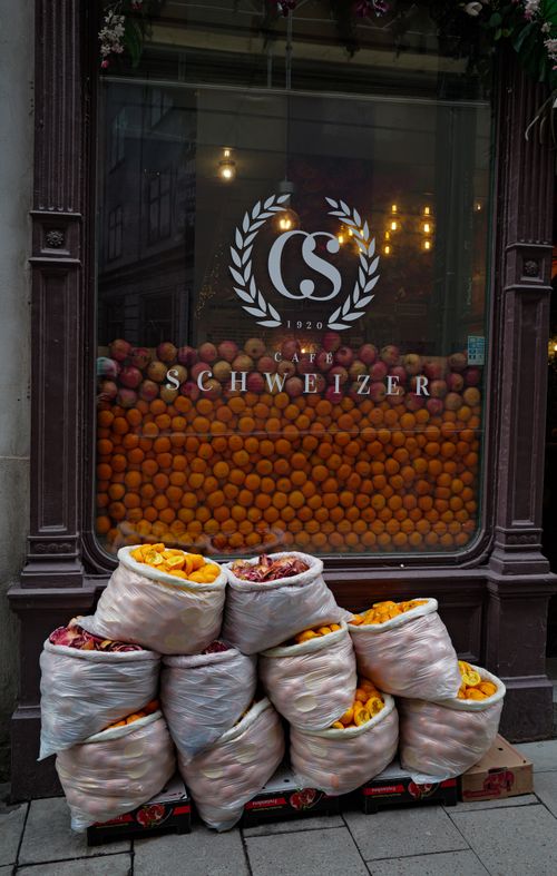 Free Café Schweizer window display in Stockholm with vibrant oranges and grapefruits neatly stacked outside. Stock Photo