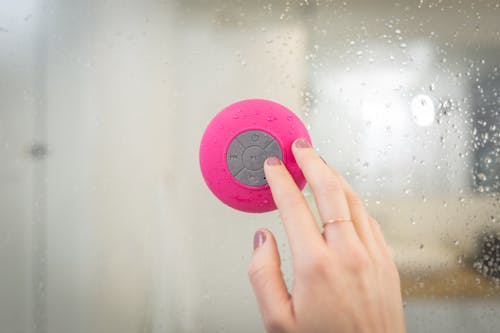 Person Holding Pink and Gray Button