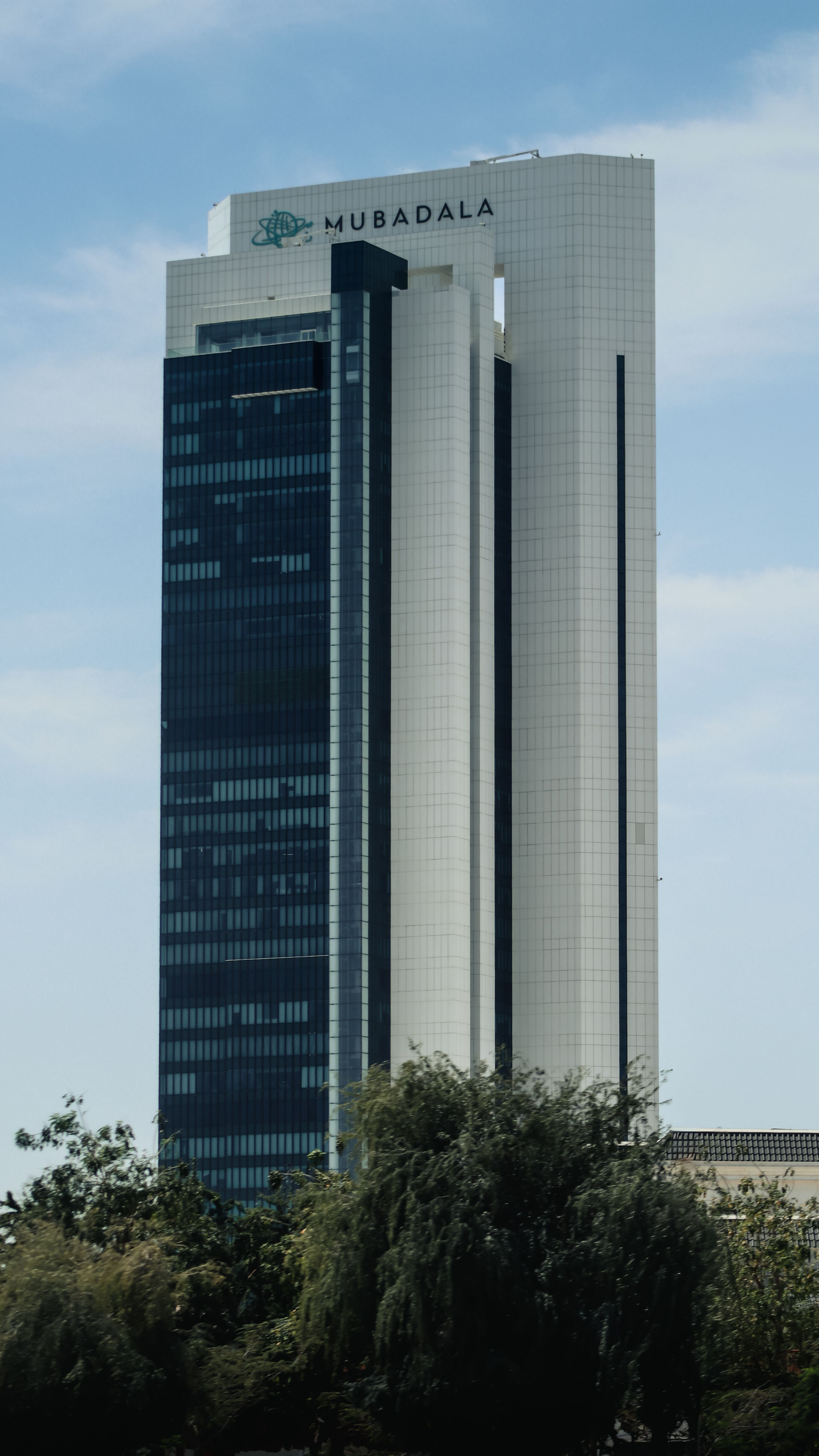 The Mubadala Tower against a clear blue sky in Abu Dhabi, United Arab Emirates.