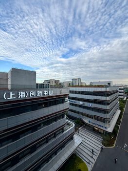 Aerial view of innovative office buildings under a scenic sky in Shanghai, China.