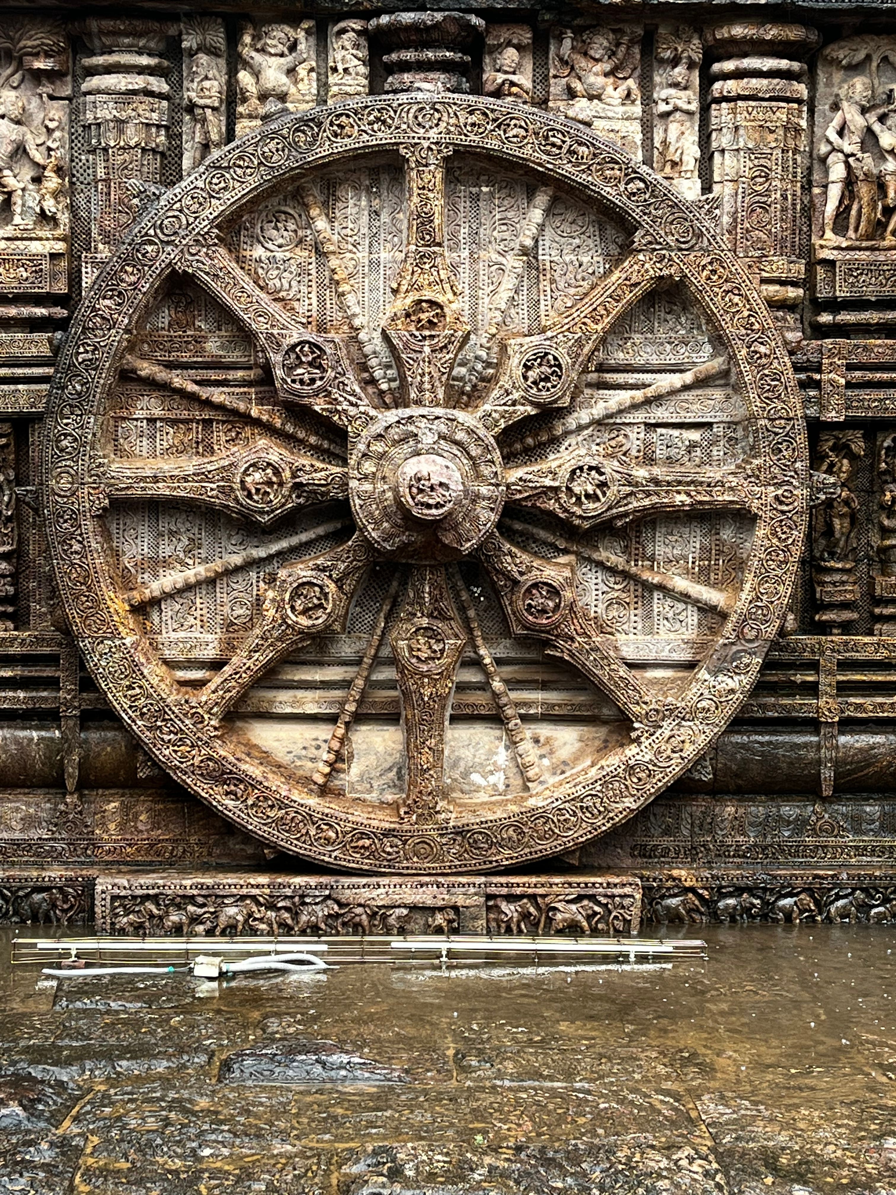 Close-up of the ornate stone wheel carving at Konark Sun Temple, showcasing ancient Indian architecture.