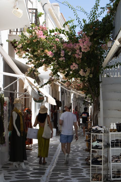 Free Tourists stroll under blooming bougainvillea in Paros, Greece. Stock Photo