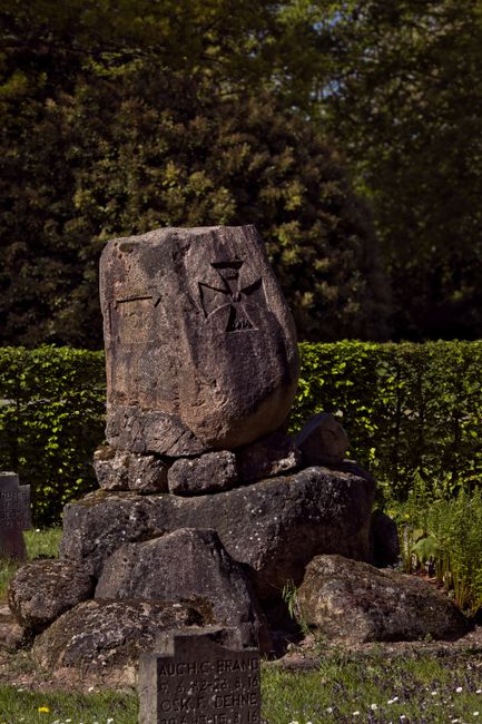 Fotomural Fotografía de un monumento rústico de piedra en un sereno cementerio histórico.