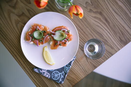 Delicious salmon and capers appetizer on a wooden table setting with lemon slice.