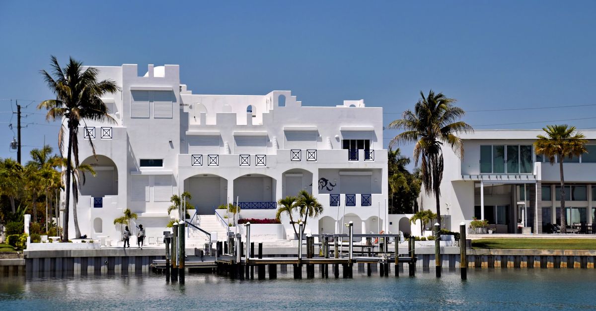 Stunning white modern waterfront house in sunny Sarasota, Florida alongside tranquil waterway.