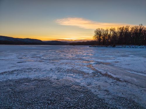 Free A serene winter sunset over a frozen lake in West Newton, Minnesota, USA. Stock Photo