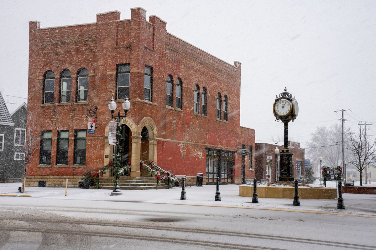Brick municipal building with a street clock in winter